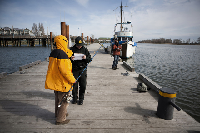 Checking the tidal fishing licence and gear of a recreational fisherman. Photo by Trevor Meier